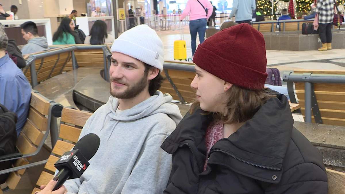 Liam Doucette and Jada Farabet sit at the Halifax airport.