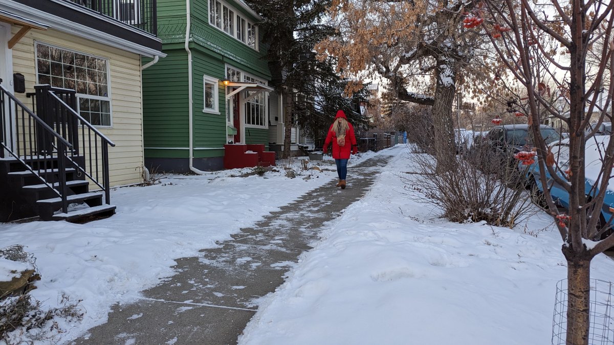 file photo of a woman walking along the sidewalk in Calgary on Dec. 2, 2022.