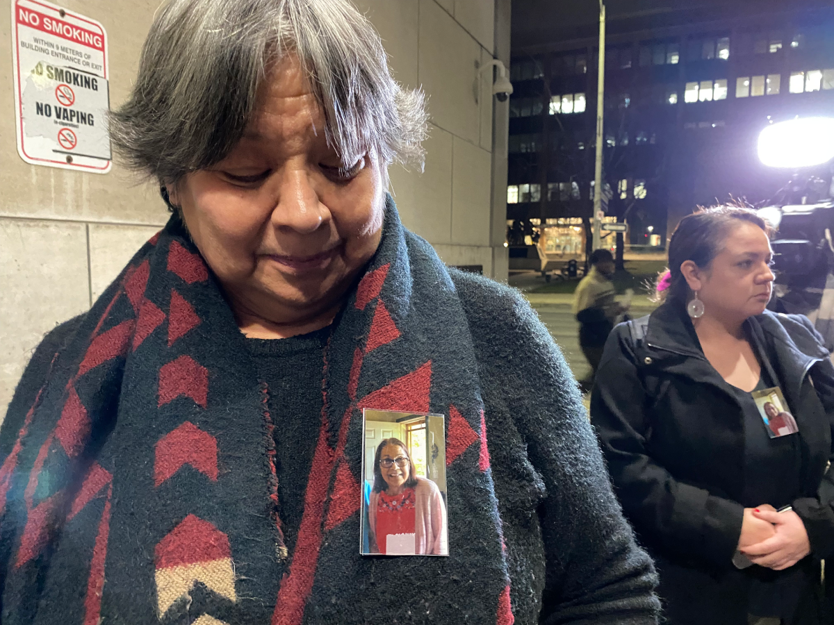 Jonathan Styres' aunt Rhonda Johns shows media a photo of Debbie Hill, Styres' mother, pinned to her scarf. Hill is in hospital and was unable to attend the trial for her son's killer.