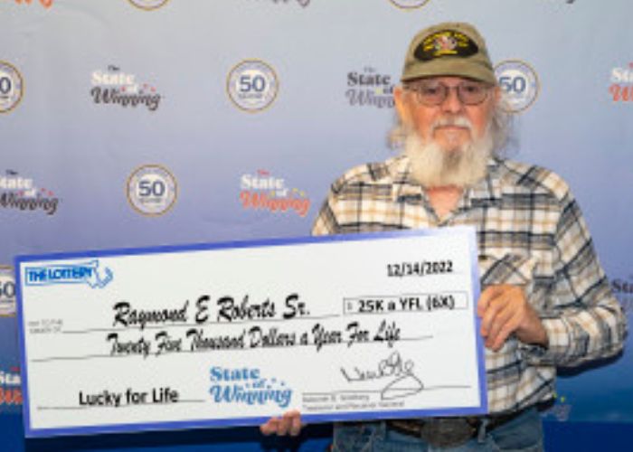 Raymond Roberts Sr. holding a fake cheque.
