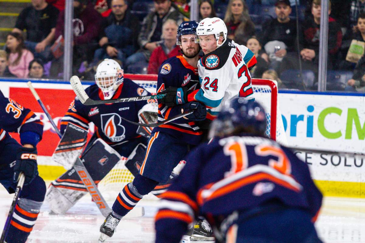 Ethan Brandwood of the Kamloops Blazers, left, and Dylan Wightman of the Kelowna Rockets battle for position during WHL action in Kelowna, B.C., on Tuesday night, Dec. 27, 2022. Kamloops won 6-4.