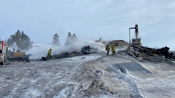Bentley firefighters douse the smoldering remnants of the grain elevator.