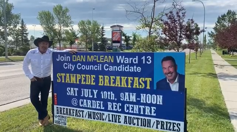 Coun. Dan McLean stands in front of a billboard promoting a campaign-style Stampede breakfast, in a video posted on July 8, 2021.