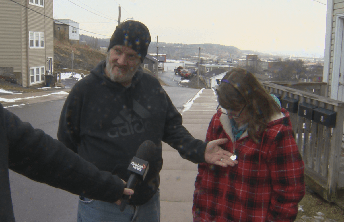 a man holds a necklace that reads "Happy to be here"