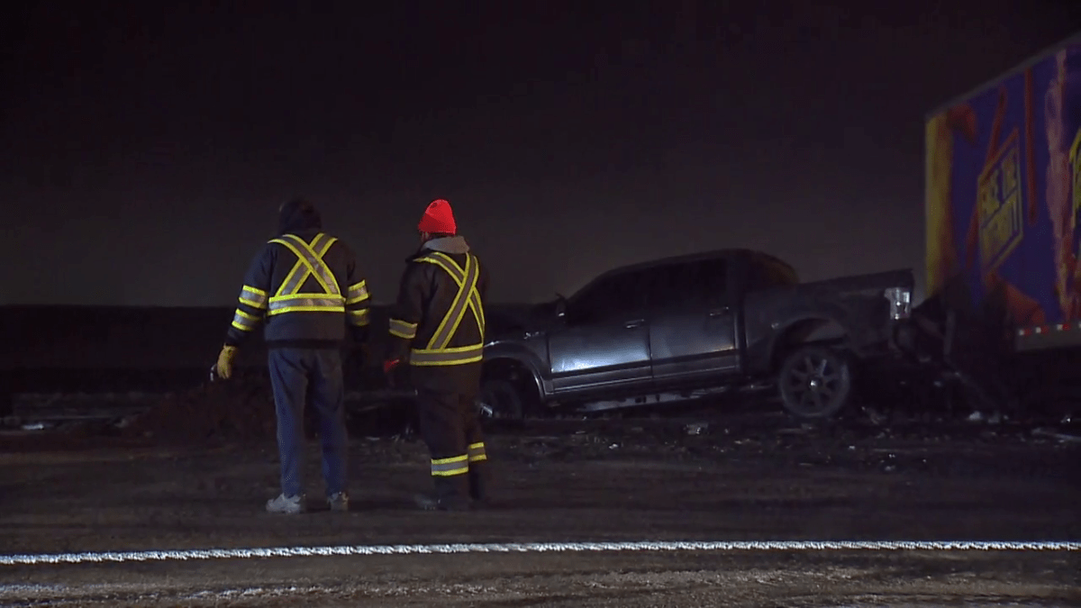 A photo of two workers surveying the crash site on Highway 2 on Dec. 27, 2022.
