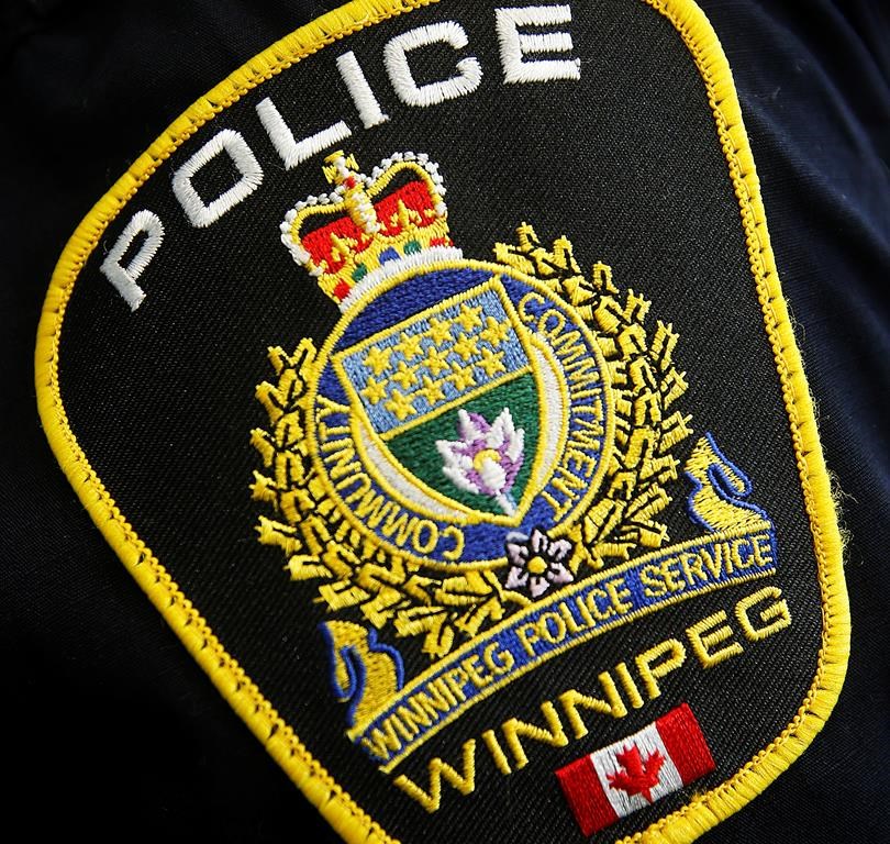 A Winnipeg Police Service shoulder badge is shown on an officer.