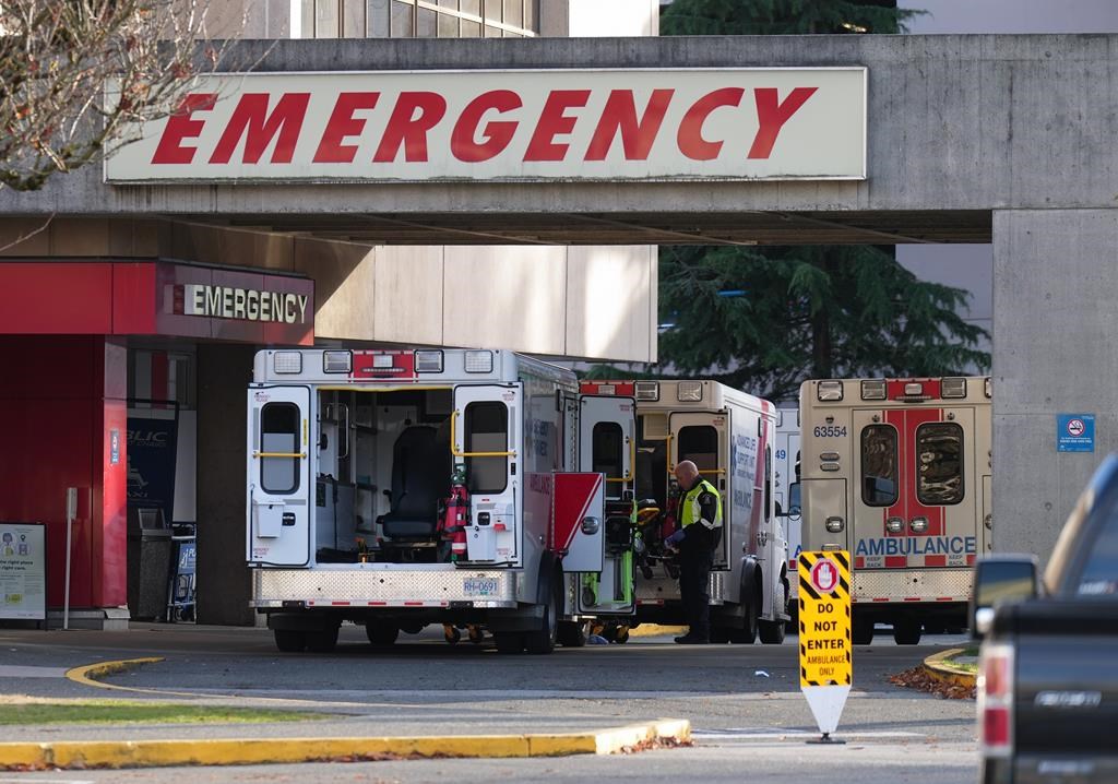 FILE. A paramedic is seen outside ambulances parked at the entrance to the emergency department at Richmond General Hospital, in Richmond, B.C., Sunday, Nov. 27, 2022.  
