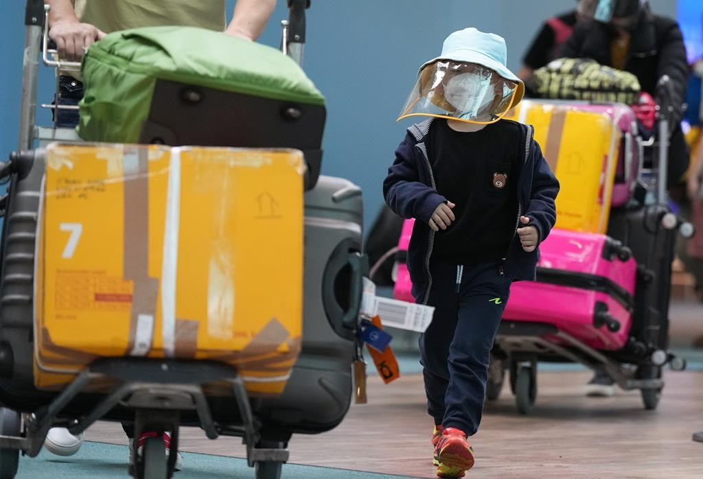 A young boy who arrived on a Cathay Pacific flight from Hong Kong wears a face mask and face shield at Vancouver International Airport, in Richmond, B.C., on Wednesday, Jan. 4, 2023. THE CANADIAN PRESS/Darryl Dyck.