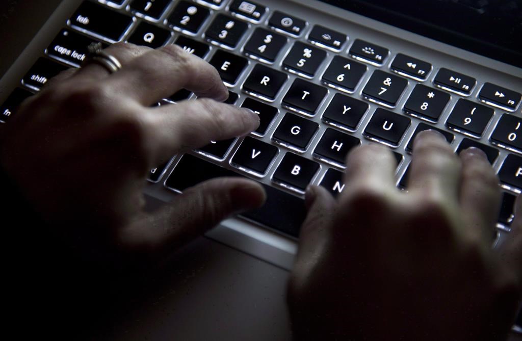 FILE - A woman uses a computer keyboard in North Vancouver on December, 19, 2012.