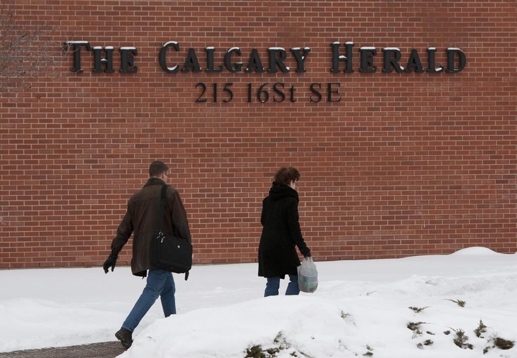 Employees make their way to the front doors of the Calgary Herald in Calgary, Alta., on Friday, Jan. 8, 2010. Newspaper publisher Postmedia says it has sold the Calgary Herald building for $17.25 million to U-haul Co. THE CANADIAN PRESS/Sean Kilpatrick.