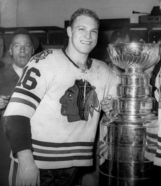 In this April 16, 1961, file photo, Chicago Blackhawks hockey player Bobby Hull smiles in the dressing room beside the Stanley Cup after Chicago defeated the Detroit Red Wings, 5-1, to win the NHL Championship, in Detroit.