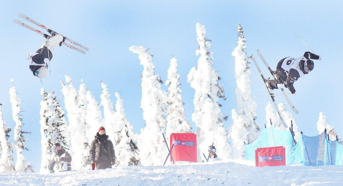 Brady Parsons, left, of Penticton, B.C.’s Apex Freestyle Club and Dylan Marcellini of the United States compete during Nor-Am dual moguls action near Penticton. Watching in the background is U.S. coach Josh Kober, a former Apex Freestyle Club member.