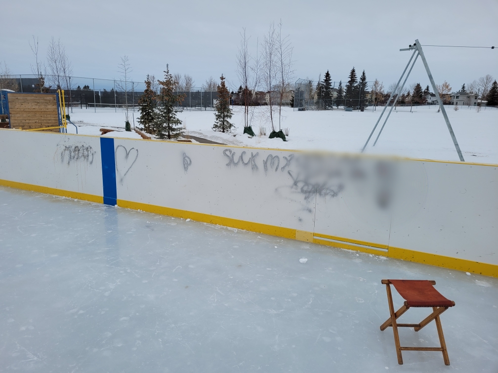 Graffiti on a rink board at the Hawkwood community outdoor rink in Calgary.