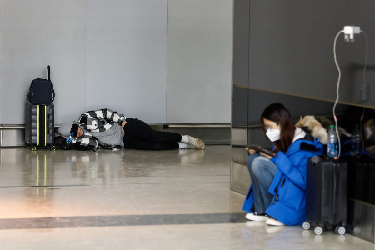 Travellers wait at Toronto Pearson International Airport, as a major winter storm disrupts flights in and out of the airport, in Toronto, Saturday, Dec. 24, 2022. THE CANADIAN PRESS/Cole Burston