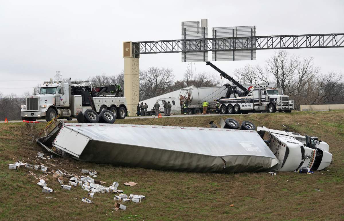 Officials investigate an accident involving 18-wheelers on SH 130 south of Texas 71, in Austin, Texas, during an ice storm on Tuesday Jan. 31, 2023. Winter weather is bringing ice to a wide swath of the United States, causing the cancellation of more than 1,600 flights nationwide and knocking out power to thousands of Texans. ( Jay Janner /Austin American-Statesman via AP)
