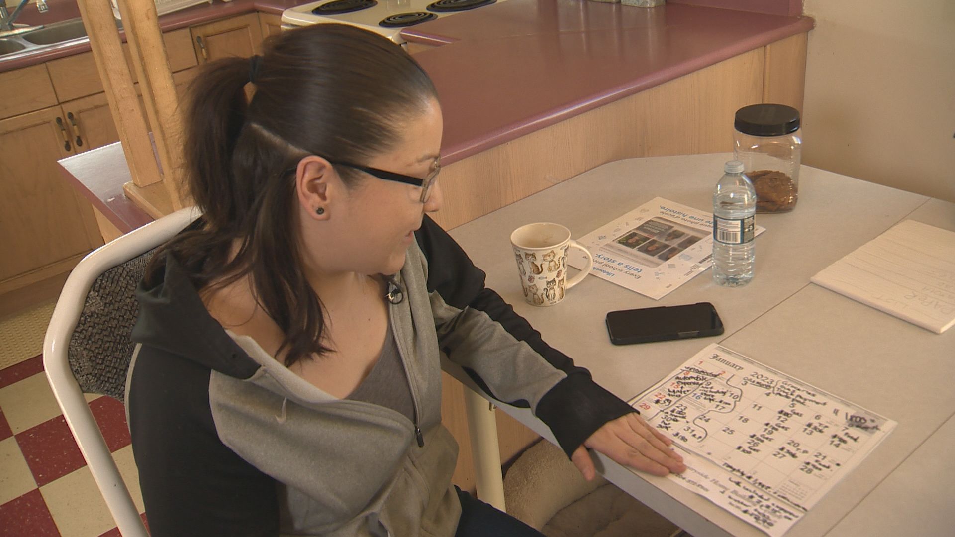 Chantel Greene, 29, flips through her wall calendar showing a detailed breakdown of expenses each month.
