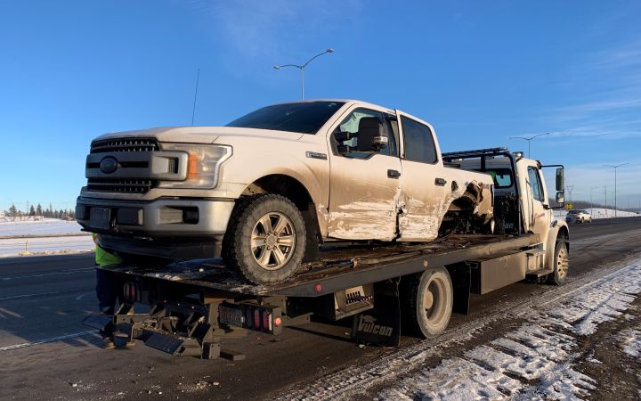 A damaged vehicle on a flatbed truck is seen on Edmonton’s Anthony Henday Drive near 170 Street on Jan. 19, 2023.