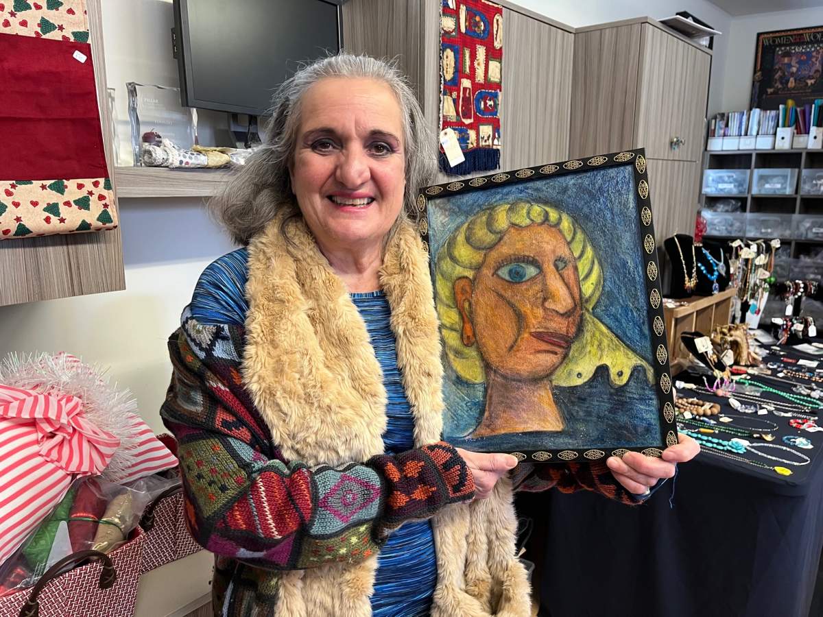 Ella Pecora holds up one of the paintings she created for the Micro Enterprise program at My Sisters’ Place.