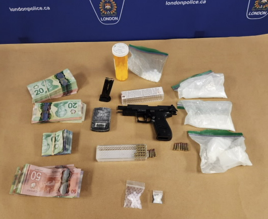 Collection of illegal drugs, handgun, ammunition and cash on a table