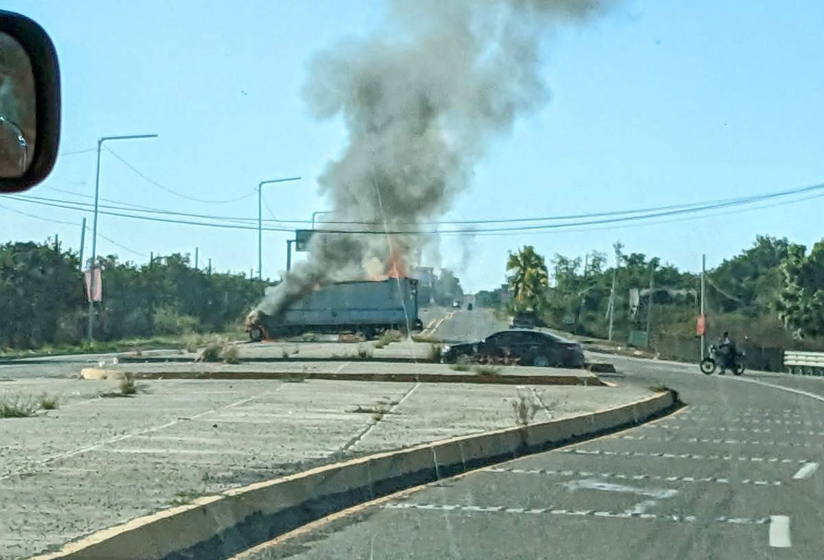 Vehicles on fire block a highway in Mazatlan, Mexico on Jan. 5, 2023, with smoke rising from the wreckage.