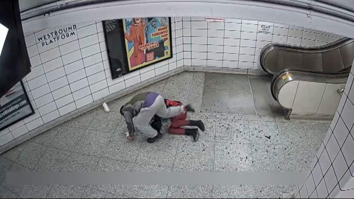Screenshot from video that appears to show a man stealing a purse from a woman at a TTC subway station.