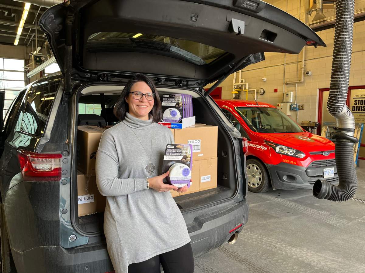 Sonja Sonnenberg poses alongside a fresh batch of combination smoke and fire alarms being donated to St. Leonard’s Community Services’ Project Home.