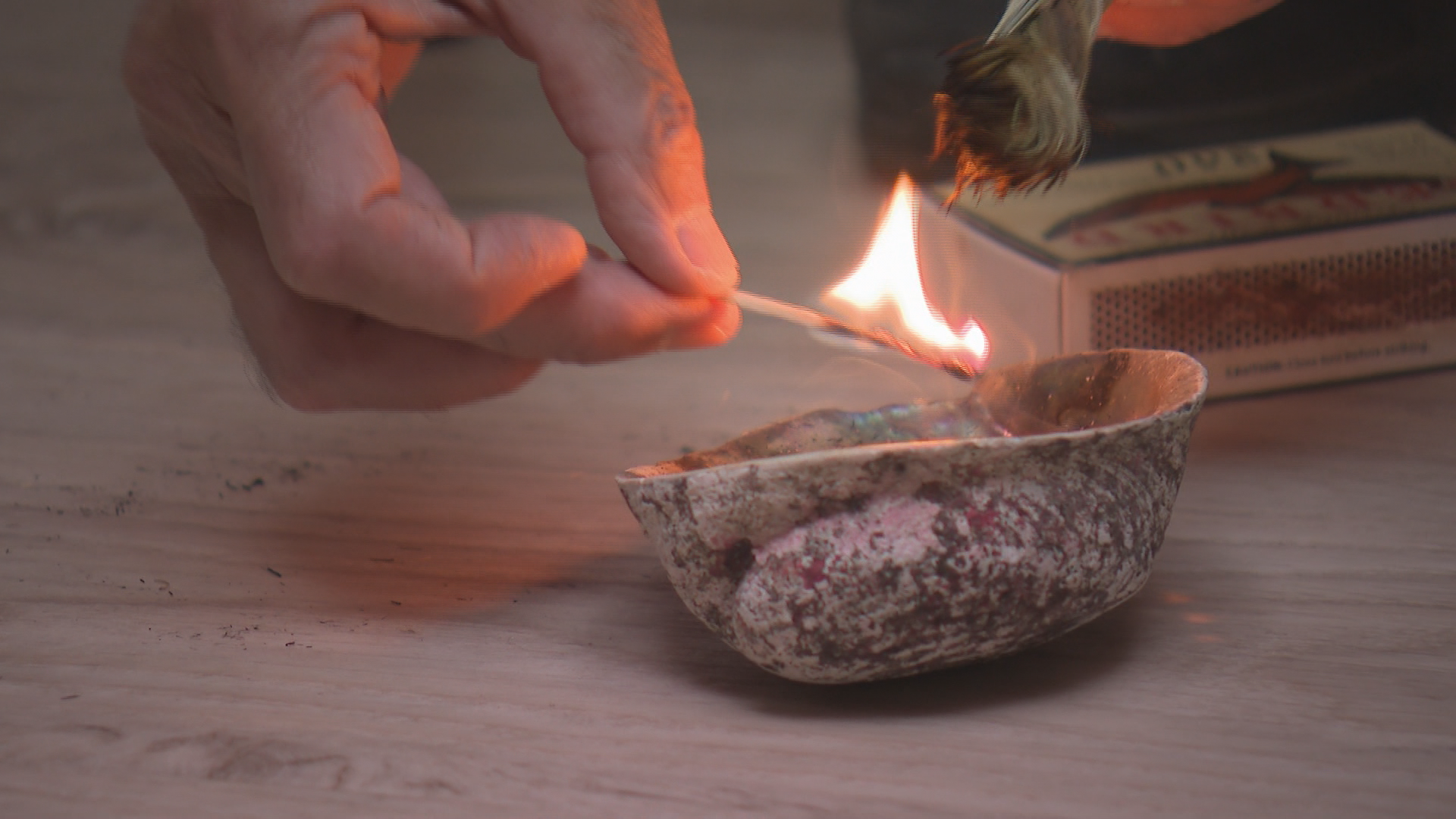 A braid of sweetgrass is lit for a smudging ceremony