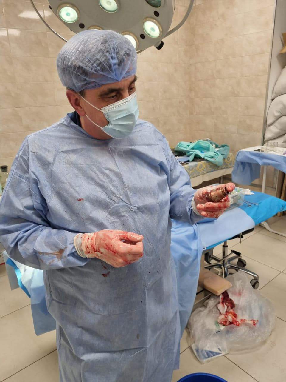 A surgeon holding an unexploded grenade that was successfully removed from the chest of a Ukrainian soldier.