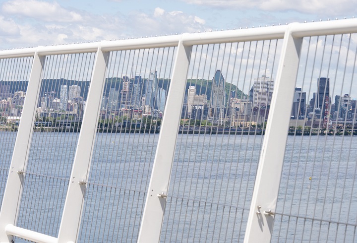 The city of Montreal is seen through the safety fence of the new Samuel de Champlain Bridge in Montreal on Monday, June 17, 2019. 