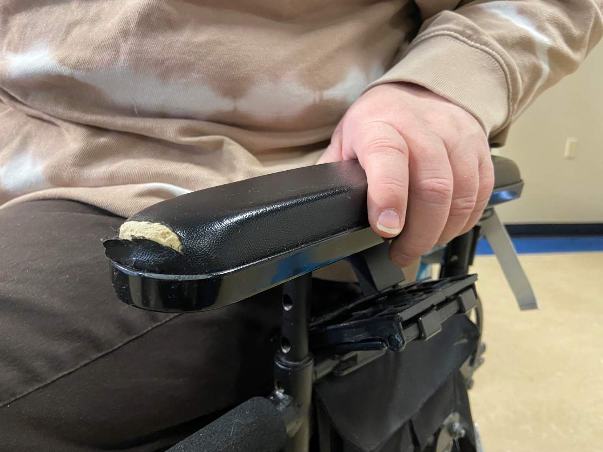 Torn armrest on her chair.