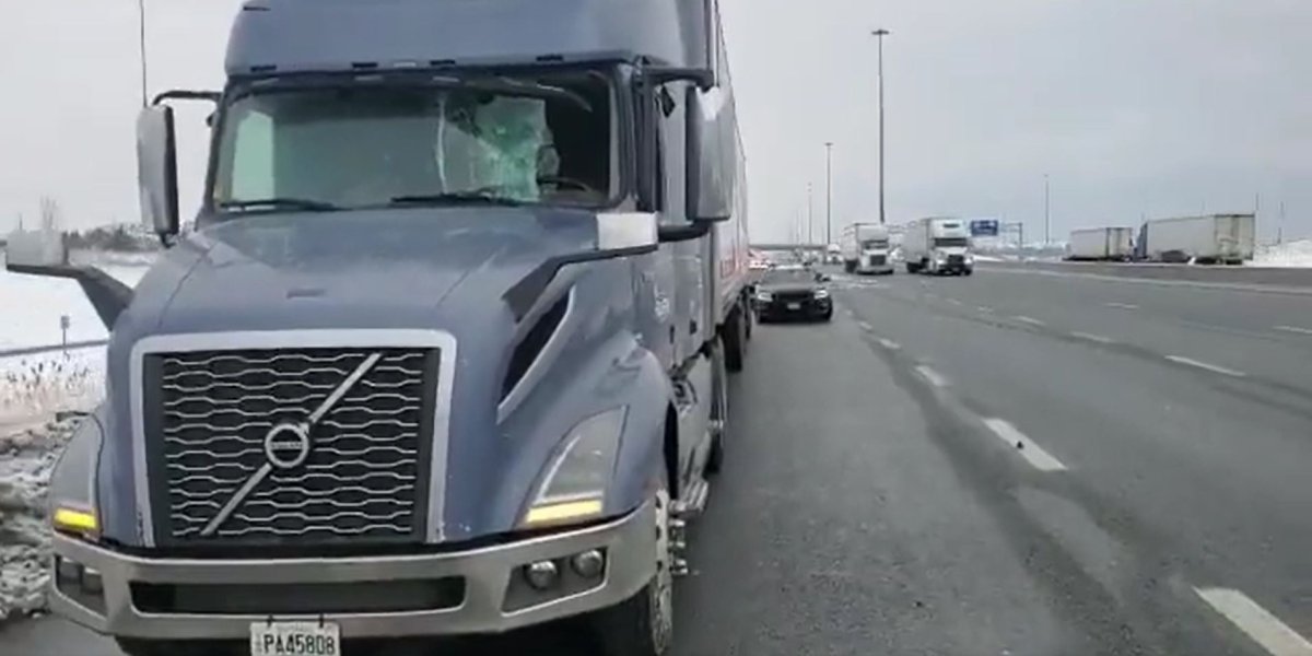 In this photo taken from a video, the windshield of a transport truck appears to be smashed.