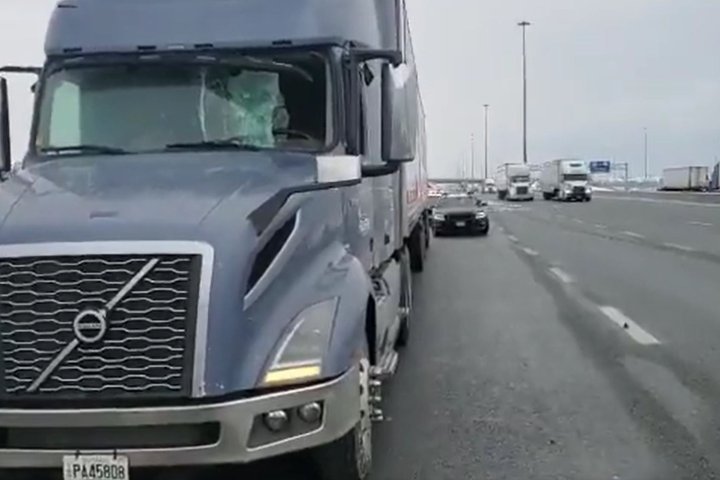 Driver taken to hospital after transport truck windshield smashed by flying ice along Hwy. 401