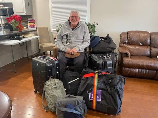 Jim Hamilton poses with luggage in his custom-built wheelchair before his flight to Chile.