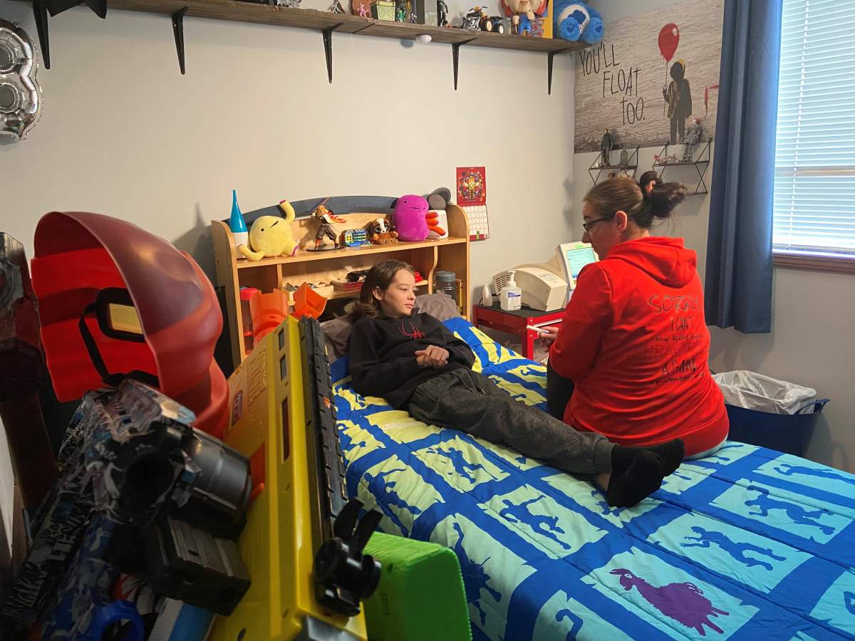 Kael Cumming and his mom Shelley Read with his dialysis machine in his bedroom.