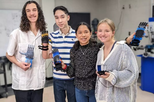 Sergio Peralta, second from left, stands with some of the classmates who helped design his prosthetic hand.
