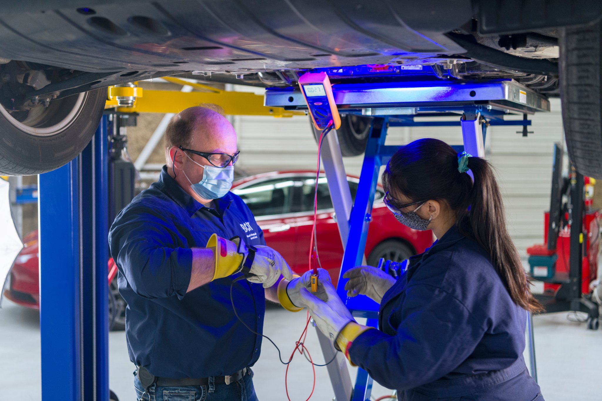 Instructor Jim Berladyn helps a student with a 'live-dead-live' test. It's to ensure no charge is coming out of the EV battery before it's removed for servicing.