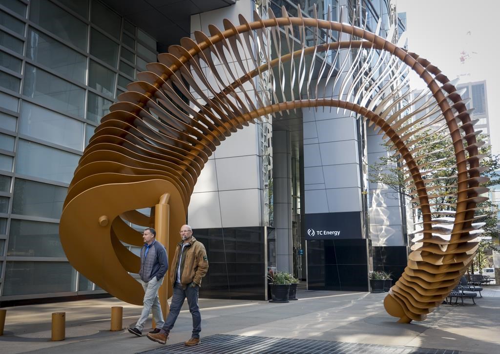 Pedestrians walk past a sculpture outside the TC Energy head office in downtown Calgary, Alta.