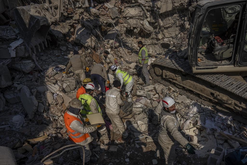 FILE – Members of a search and rescue team work on a collapsed structure after the earthquake in Antakya, southeastern Turkey, Sunday, Feb. 12, 2023.