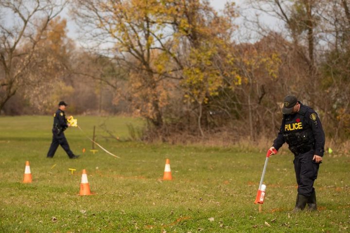 Ontario Provincial Police members take measurements during the search for unmarked graves using ground-penetrating radar on the 500 acres of land associated with the Mohawk Institute, a former Indian residential school in Brantford, Ont., Tuesday, Nov. 9, 2021. 