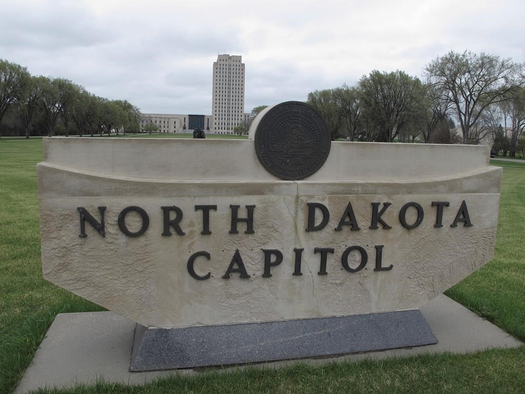 The North Dakota Capitol tower rises in the background behind a stone sign in this file photo.