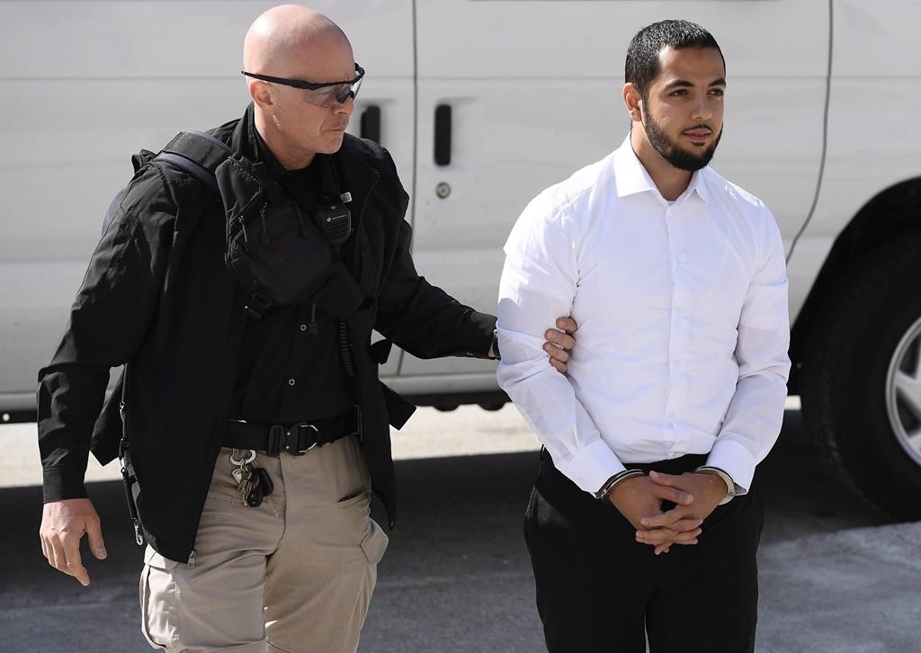 Awso Peshdary, who is accused of recruiting for ISIS, is escorted by police, Aug. 13, 2018. THE CANADIAN PRESS/Justin Tang