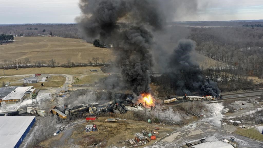 The derailed Norfolk Southern train is smoking and on fire.