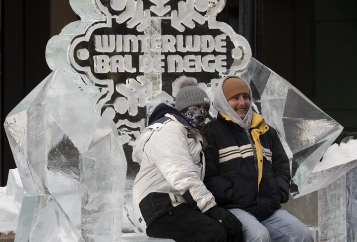 Two people sit on an ice-bench, part of an ice sculpture in downtown Ottawa, Friday, February 3, 2023. Mowafak Nema, second place winner of this year’s ice sculpting competition says weather like Ottawa has experienced this winter just means that sculptors have to adapt. 