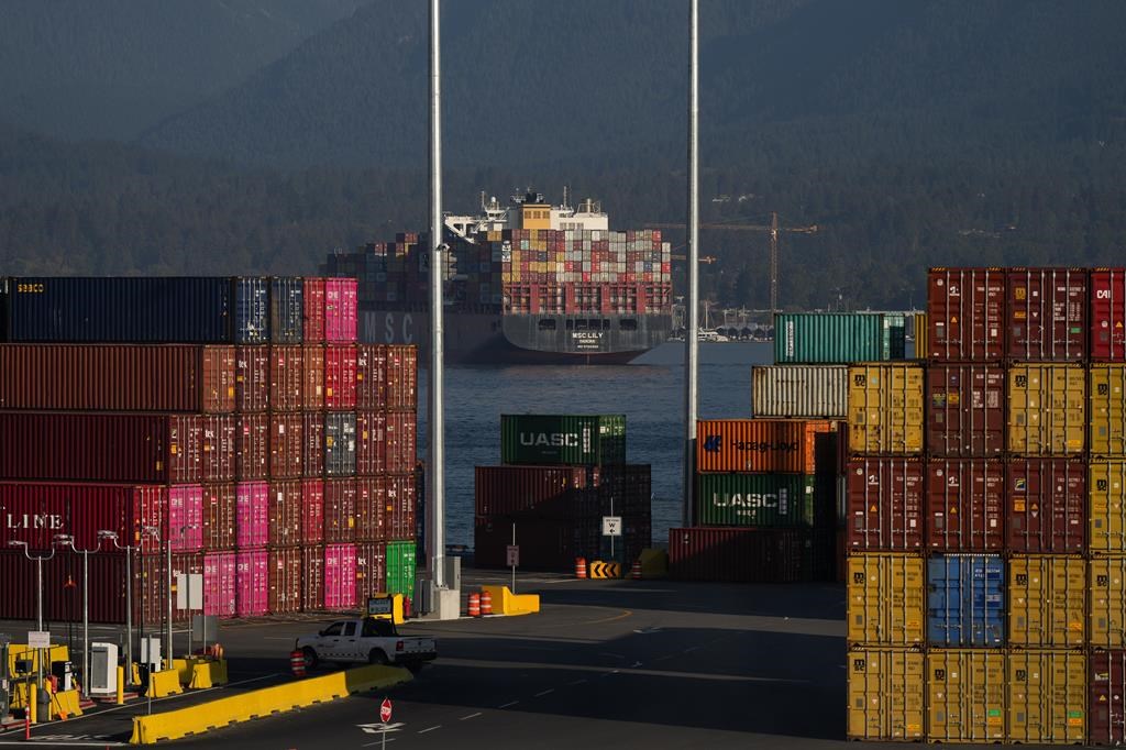 Cargo containers are seen stacked at the Port of Vancouver Centerm container terminal as the container ship MSC Lily sits at anchor in the harbour, in Vancouver, on Friday, Oct. 14, 2022.