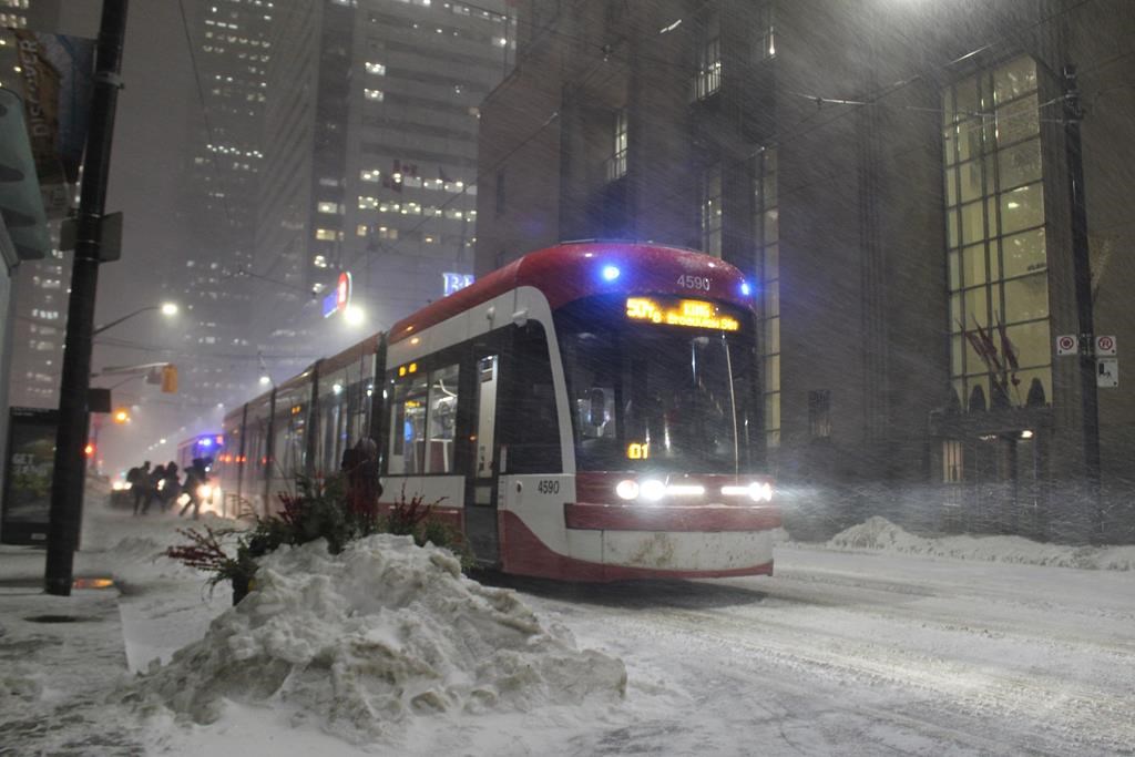 Commuters board a TTC streetcar in Toronto’s downtown core as a winter storm starts to hit the city on Monday, Feb. 27, 2023. The chief executive of the Toronto Transit Commission is asking for more emergency spending authority, which could be used to extend contracts for 50 temporary security guards brought on in the wake of a number of violent transit incidents. 