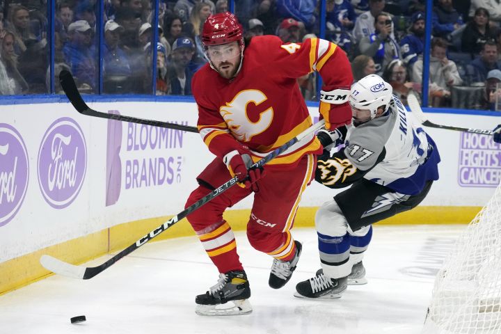 Calgary Flames defenceman Rasmus Andersson (4) moves the puck ahead of Tampa Bay Lightning left wing Alex Killorn (17) during the second period of an NHL hockey game Thursday, Nov. 17, 2022, in Tampa, Fla.