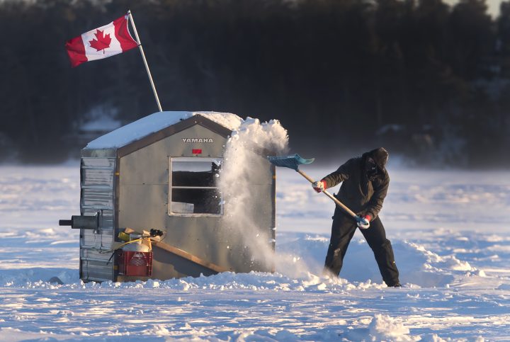 John Harris, from Pontypool, Ontario clears snow around ice hut on Pigeon Lake in central Ontario Friday February 3, 2023. Frigid temperatures are expected to continue through tomorrow in Ontario and eastwards.  
