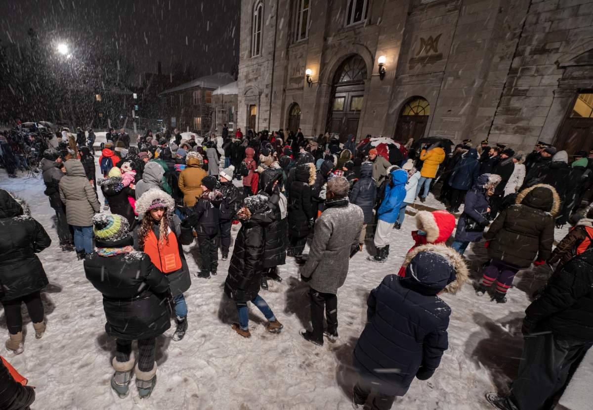 People gather for a vigil at a church near the site of a daycare centre where two children lost their lives after a city bus crashed into the building in Laval, Que, Thursday, February 9, 2023. THE CANADIAN PRESS/Peter McCabe