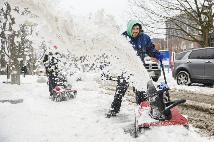 Service workers clear snow following a winter storm that affected southern Ontario, in Toronto, on Thursday, Feb., 23, 2023. 