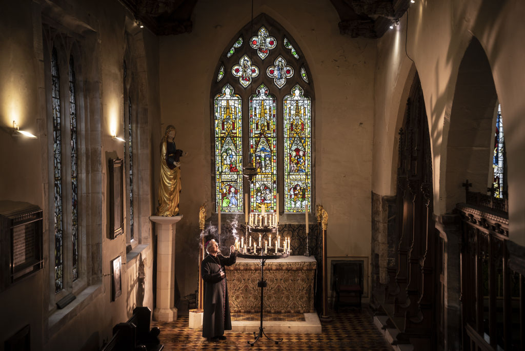 File - The Rt Reverend Glyn Webster lights a candle in front of the newly restored Lady Chapel East Window at All Saints North Street in York.